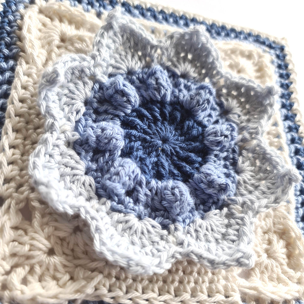 Close up of Charlene granny square crochet pattern by Shelley Husband in blues and cream