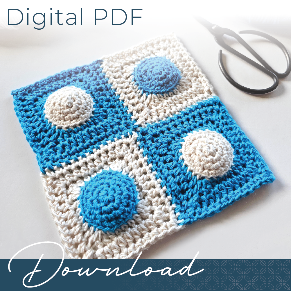 A joined 2 by 2 grid of four granny squares crocheted in blue and parchment, with a pair of black yarn scissors.