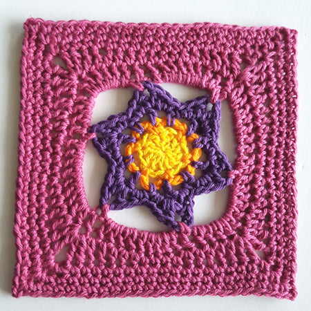 Aegean granny square in four colours, pink outside, then purple, then orange and yellow by Shelley Husband