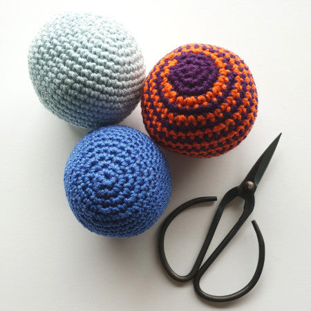 3 balls from Intro to amigurumi by Shelley Husband with a pair of black yarn scissors