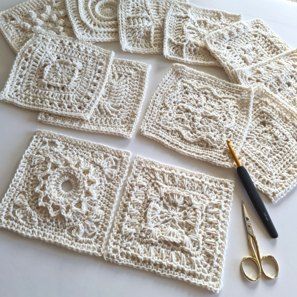 Granny squares from Granny Square Academy 2 with a black handled crochet hook and a pair of gold yarn scissors