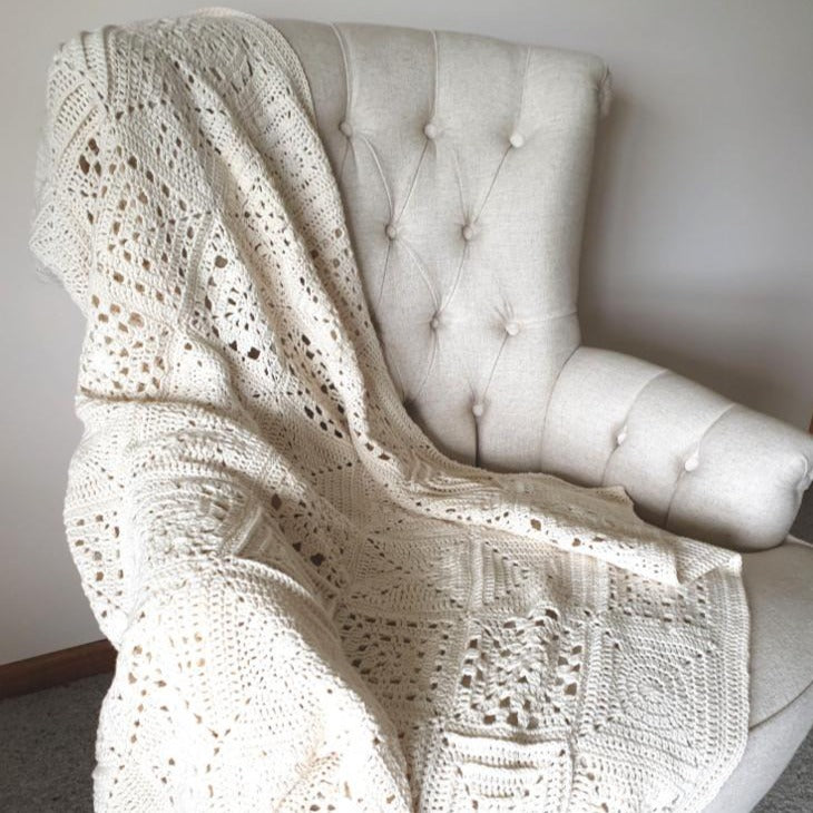 Granny Square Academy sampler blanket over a wingback chair by Shelley Husband