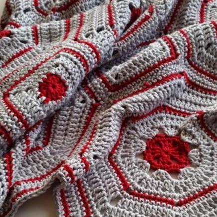 Close up of Galapagos Blanket Pattern by Shelley Husband rumpled in red and grey