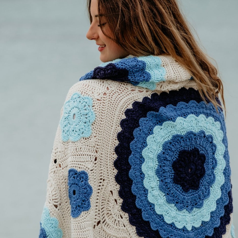 Manderley Crochet Blanket by Shelley Husband wrapped around a brunette woman with back facing camera