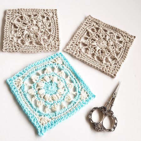 Three Mayan Mini Taster pattern granny squares with a pair of ornate yarn scissors by Shelley Husband