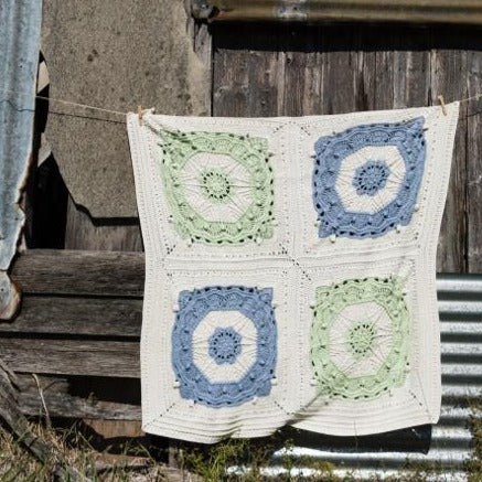 Three colour Mayan Crochet Blanket Pattern hanging on a line in front of a shed by Shelley Husband