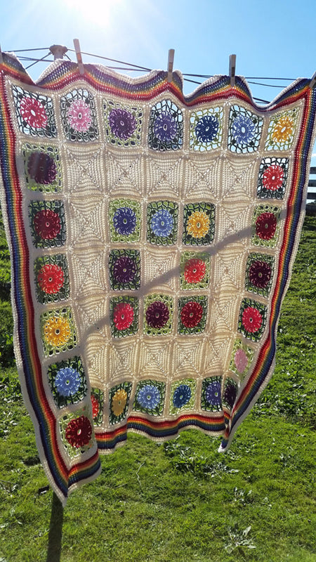 Posies and Pickets Blanket Pattern by Shelley Husband hanging from a clothes line