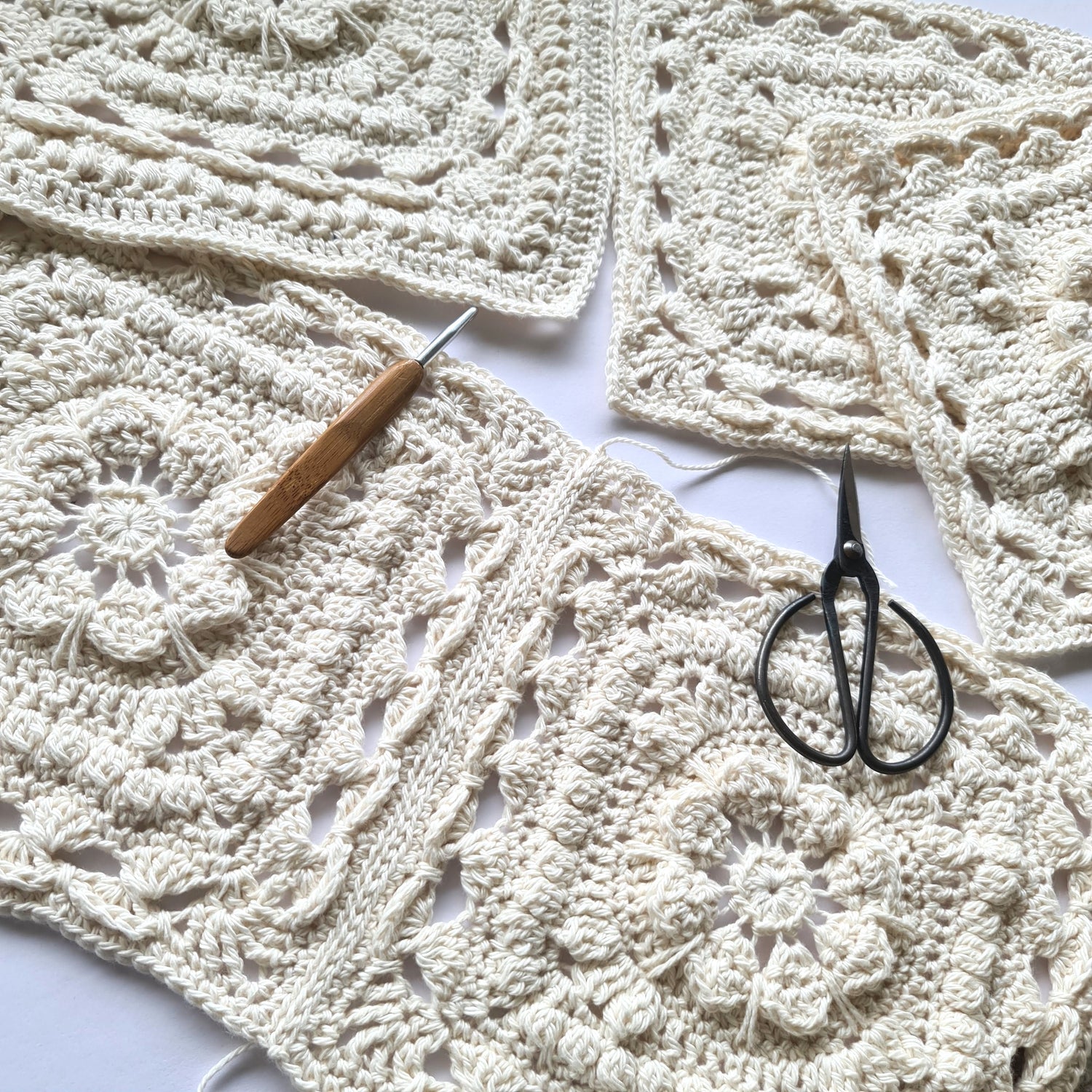 Cream single colour granny squares from Persnickety Blanket crochet pattern by Shelley Husband with a crochet hook and black yarn scissors