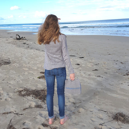 Woman on beach holding the Slipstream Project Bag by Shelley Husband