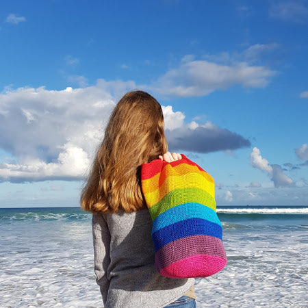 Woman on beach holding Spectrum Project Bag by Shelley Husband