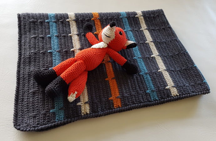 Folded This Charming Boy Baby Blanket by Shelley Husband with a crochet fox on top